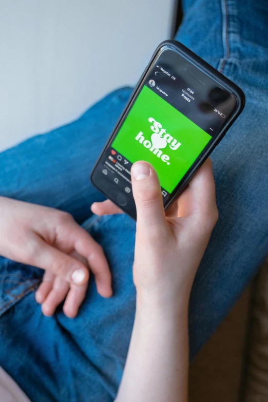 a close up of a person holding a cell phone, green and black colors, home, arney freytag, gen z