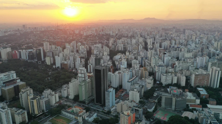 an aerial view of a city at sunset, by Ceferí Olivé, happening, hosada, city high-rise, paradise in the background, photo taken in 2018