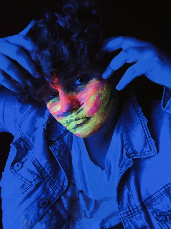 a close up of a person with a painted face, an album cover, inspired by John Luke, trending on pexels, holography, bisexual lighting, ((blue)), color splash, color lights