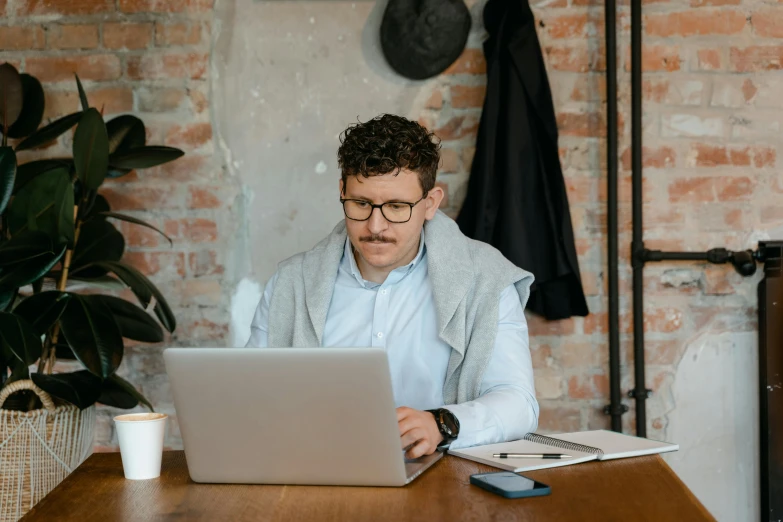 a man sitting at a table with a laptop, a screenshot, pexels contest winner, lightly dressed, caucasian, working, 1450