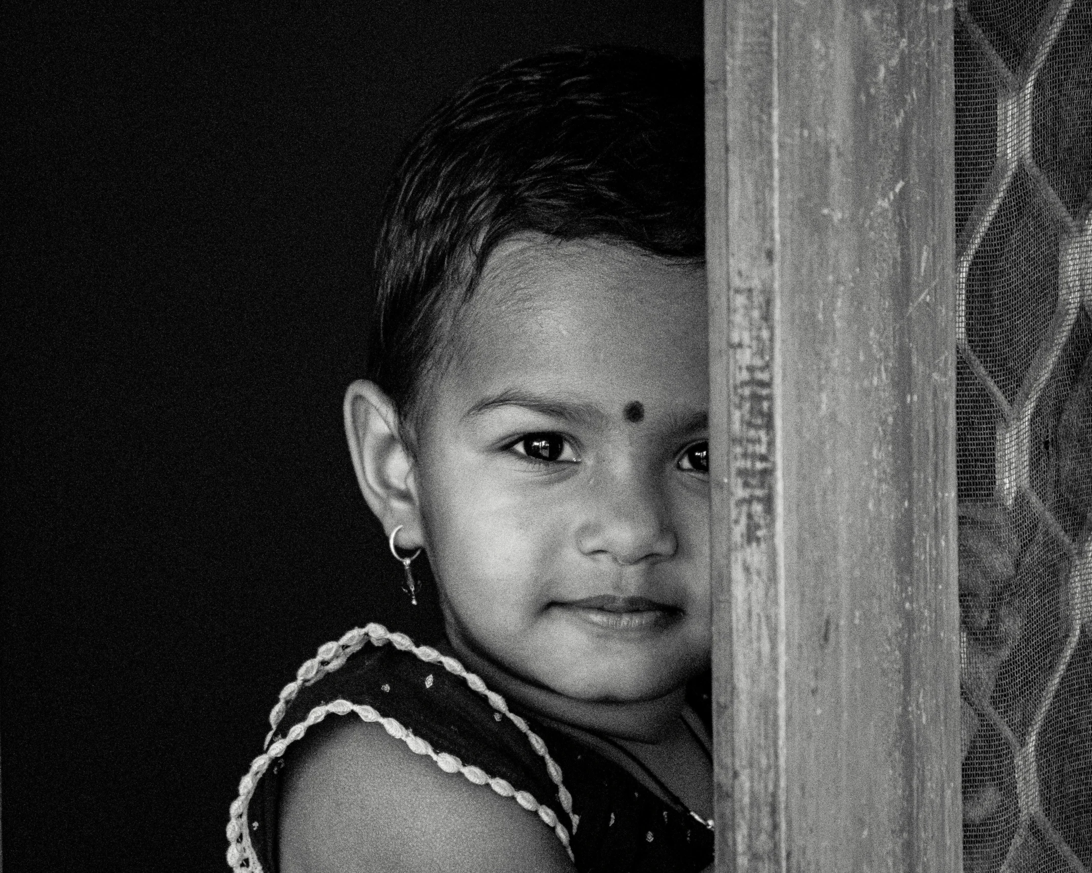 a black and white photo of a little girl, by Sudip Roy, pexels contest winner, young cute face, colours, indian ink, posed