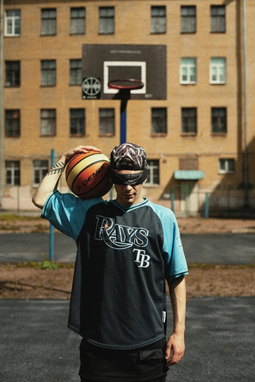a man holding a basketball on top of his head, by Attila Meszlenyi, dribble contest winner, sleek blue visor for eyes, baggy clothing and hat, ilya kuvishinov style, in the yard