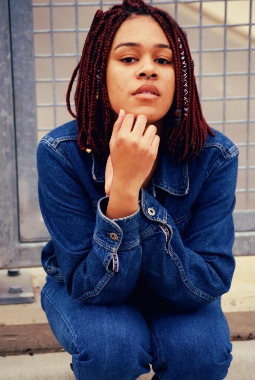 a woman with dreadlocks sitting on a step, inspired by Kaja Foglio, trending on pexels, denim jacket, with index finger, with a bob cut, mixed race woman