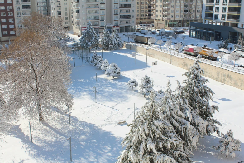 a street filled with lots of snow next to tall buildings, a photo, bauhaus, with a park in the background, tehran, thumbnail, overview