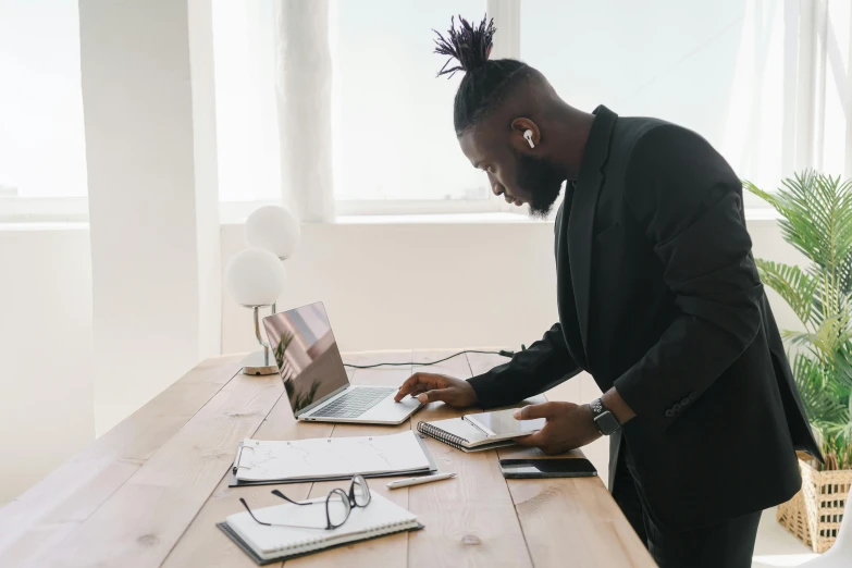 a man in a suit working on a laptop, pexels contest winner, standing on a desk, black people, minimalist home office, official screenshot