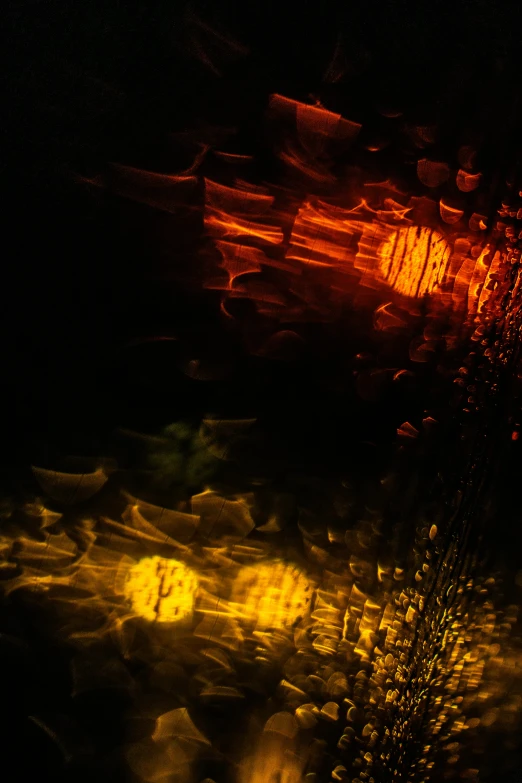 a blurry image of a street at night, an album cover, by Jan Rustem, unsplash, lyrical abstraction, gold refractions off water, yellows and reddish black, detailed droplets, high detailed light refraction