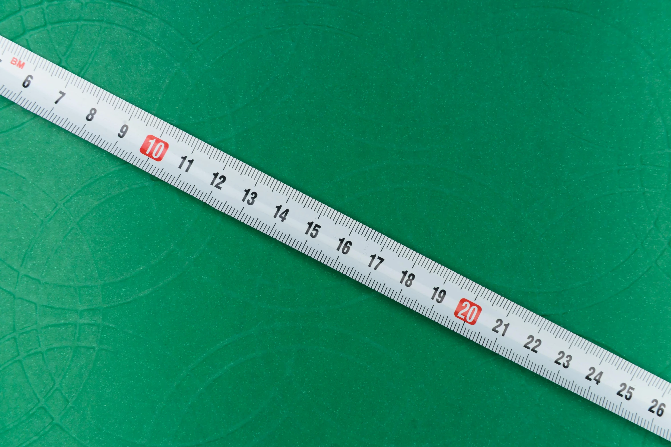 a close up of a measuring tape on a green surface