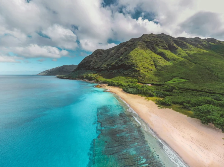 a beach with a mountain in the background, a photo, aerial, hawaii beach, light blue water, beach is between the two valleys