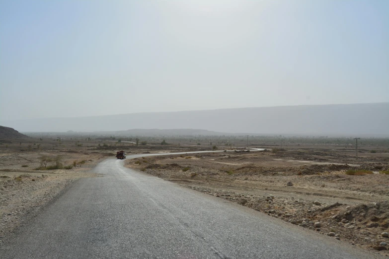 a person riding a motorcycle down a dirt road, les nabis, afar, distant photo, background image, highways