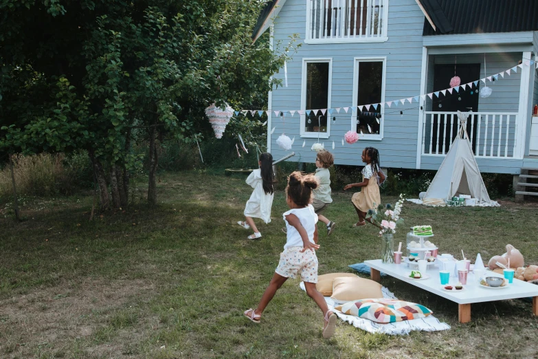 a group of people that are standing in the grass, cottage, playing, white finish, with paper lanterns