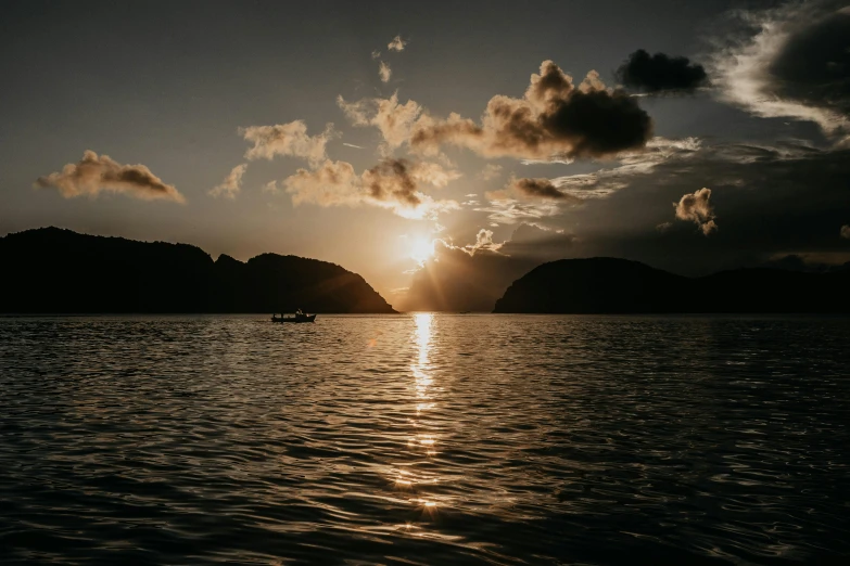 the sun is setting over a body of water, pexels contest winner, fan favorite, abel tasman, on a boat, body of water