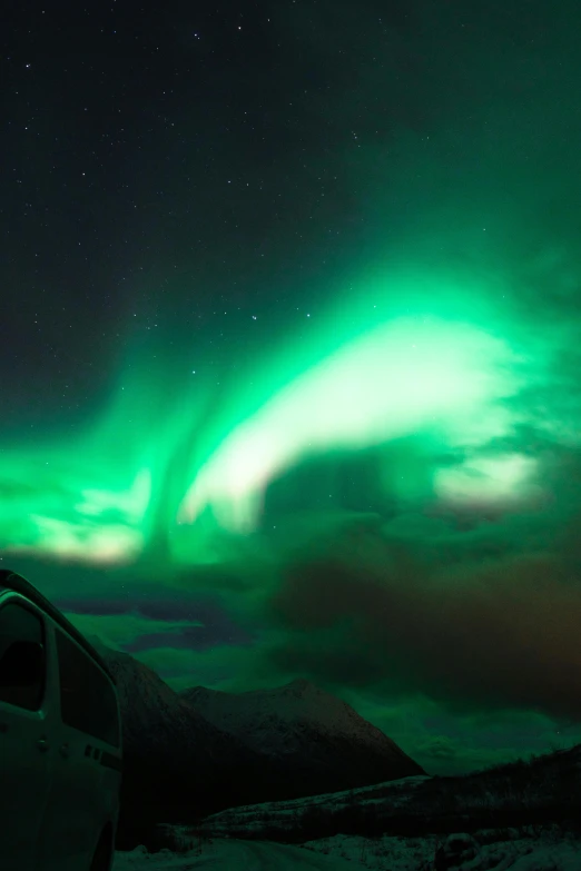 a van that is sitting in the snow, by Terese Nielsen, trending on unsplash, northern lights in space, dramatic lightin, green neon, panorama view of the sky