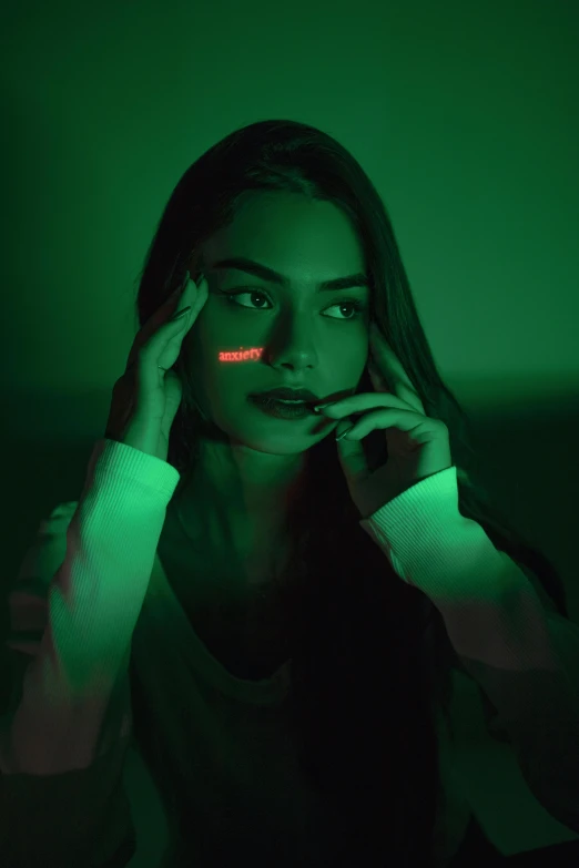 a woman sitting in the dark talking on a cell phone, inspired by Elsa Bleda, trending on pexels, holography, shades green and red, :: madison beer, markings on her face, green lightsaber