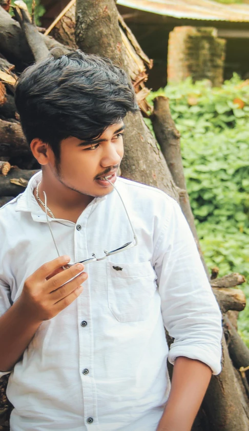 a man standing next to a pile of wood, inspired by Bikash Bhattacharjee, pexels contest winner, realism, male teenager, pouting, 15081959 21121991 01012000 4k, with sunglass