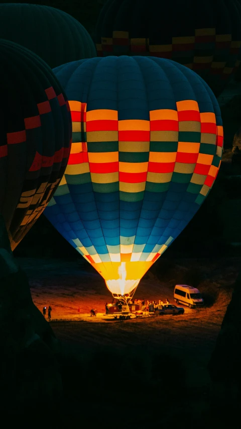 a couple of hot air balloons sitting on top of a field, a colorized photo, by irakli nadar, pexels contest winner, glowing in the dark, high angle shot, color slide, spaceship landing