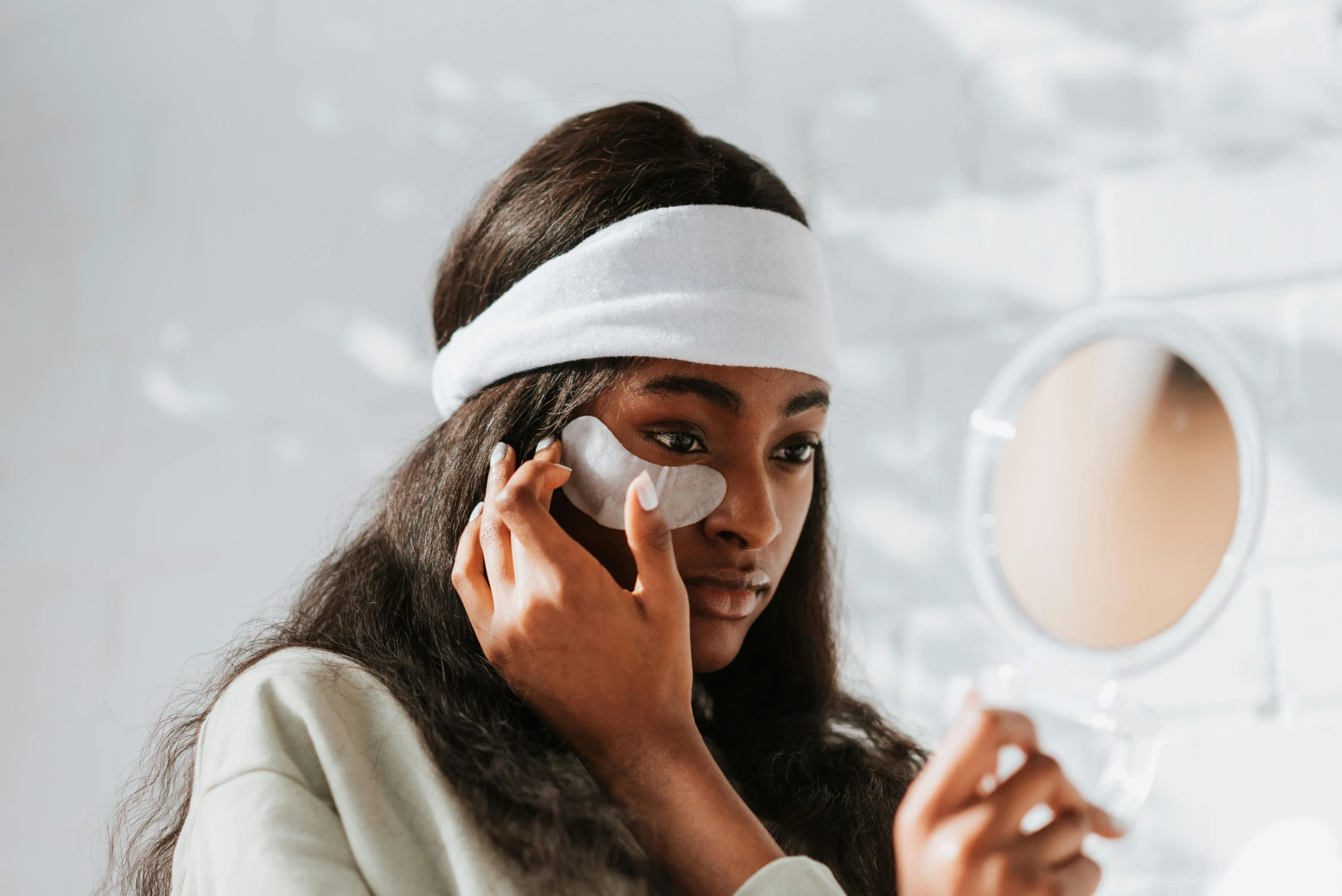 a woman talking on a cell phone in front of a mirror, trending on pexels, hurufiyya, black eye patch over left eye, wearing a headband, photoshoot for skincare brand, ( ( dark skin ) )