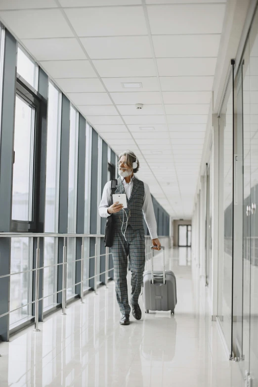 a man walking down a hallway with a suit case, an album cover, pexels, happening, airport, healthcare worker, with head phones, gray men