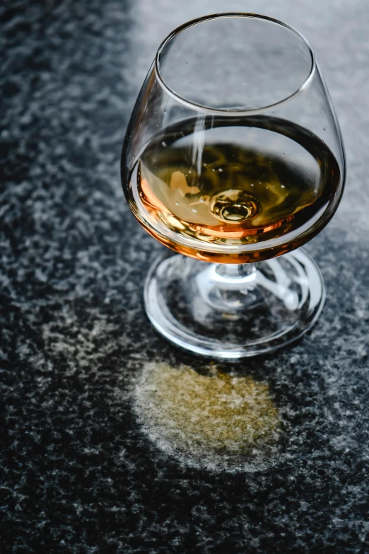 a glass of wine sitting on top of a table, inspired by William Grant Stevenson, renaissance, close up of single sugar crystal, malt, on ground, thumbnail