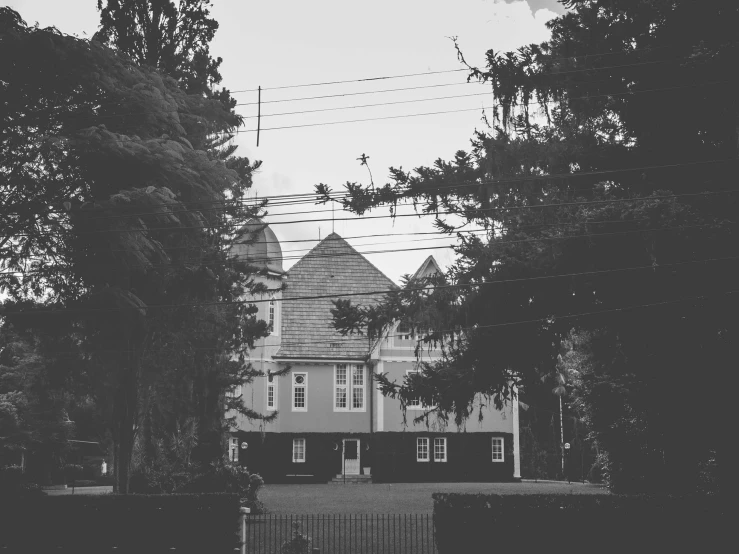 a black and white photo of a large house, by Emma Andijewska, unsplash, vancouver school, church in the wood, small town surrounding, desaturated color, official courthouse
