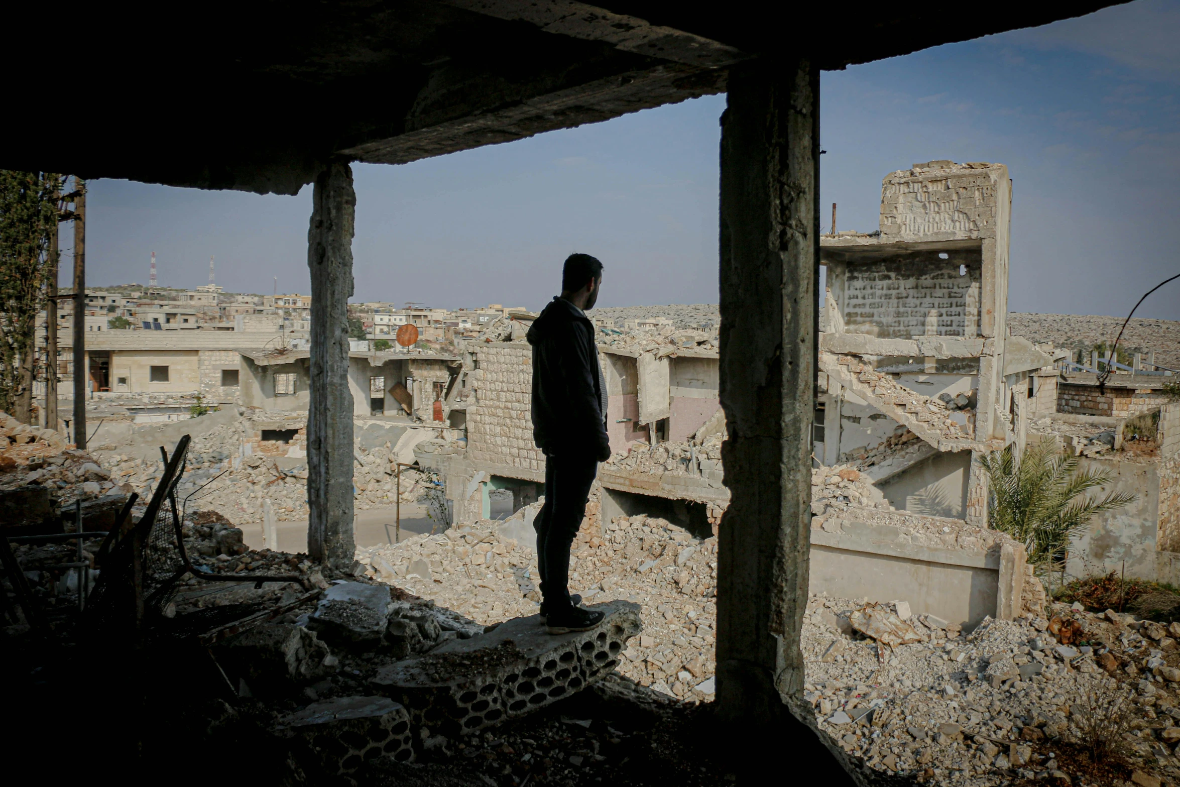 a person standing in the ruins of a building, real life photo of a syrian man, overlooking, filmstill, **cinematic