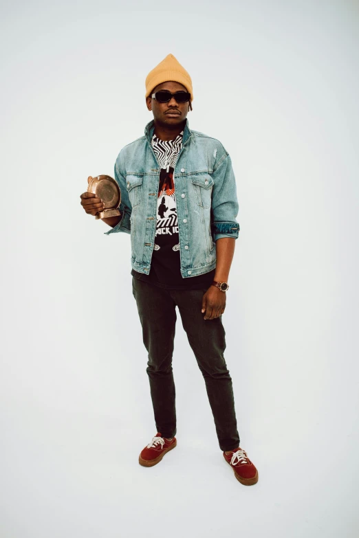 a man standing in front of a white background, an album cover, by Amos Ferguson, trending on pexels, wearing a jeans jackets, african, a person at a music festival, promotional image