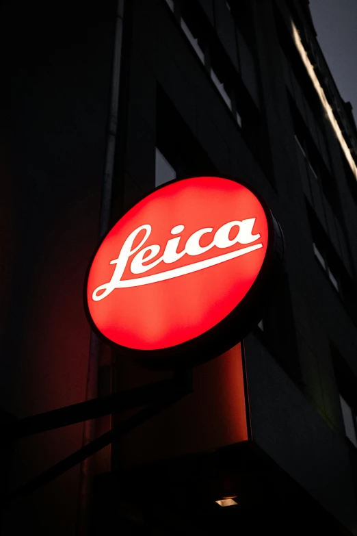a red leica sign hanging from the side of a building, inspired by Lucia Peka, lyco art, back - lit, ( ( theatrical ) ), promotional image, streetwear