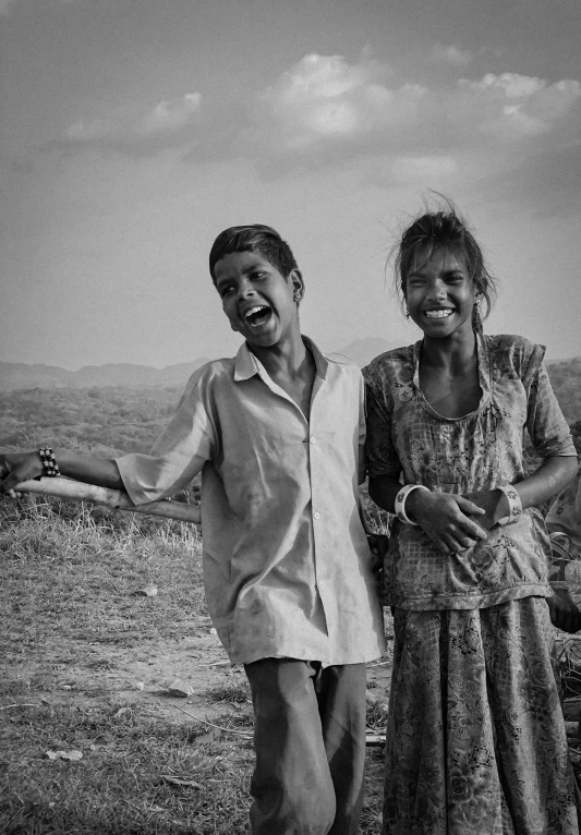 a couple of people standing next to each other, a black and white photo, by Jitish Kallat, she expressing joy, hills, smiling girl, series