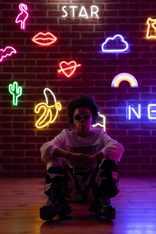 a man sitting on a skateboard in front of a neon sign, trending on pexels, with afro, light room, prince, with a cool pose