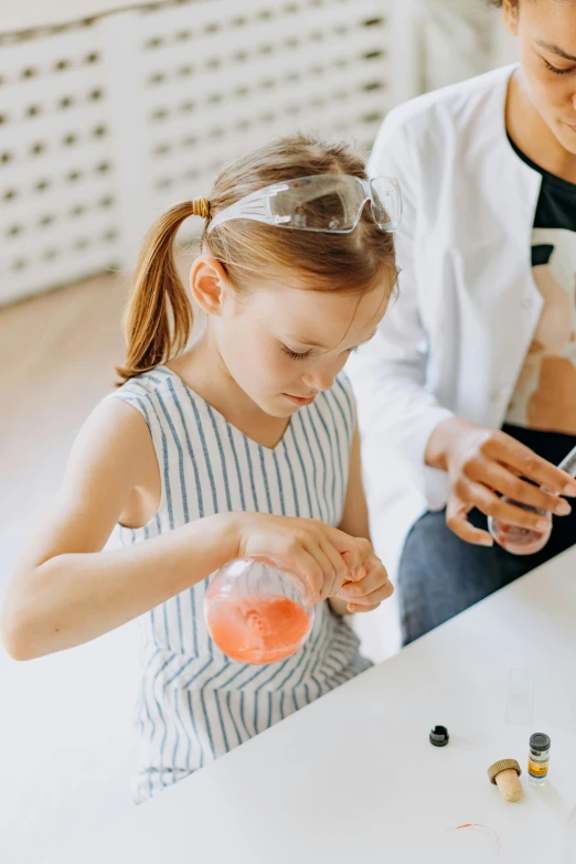 a woman and a little girl sitting at a table, experimenting in her science lab, juice, manuka, for junior