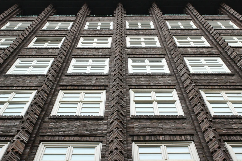 a tall brick building with lots of windows, inspired by Matthias Jung, pexels contest winner, berlin secession, brown, zig zag, window, viking palace