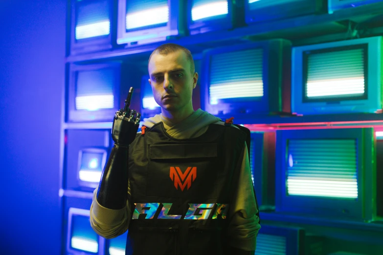 a man standing in front of a wall of televisions, cyberpunk art, inspired by Adam Marczyński, holography, model is wearing techtical vest, holding a milkor mgl, official store photo, mrbeast