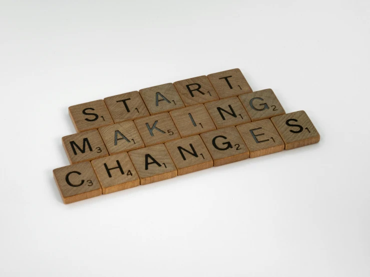 a scrabble that says start making changes, an engraving, by Jan Cox, happening, press photograph, brown, blocks, panel