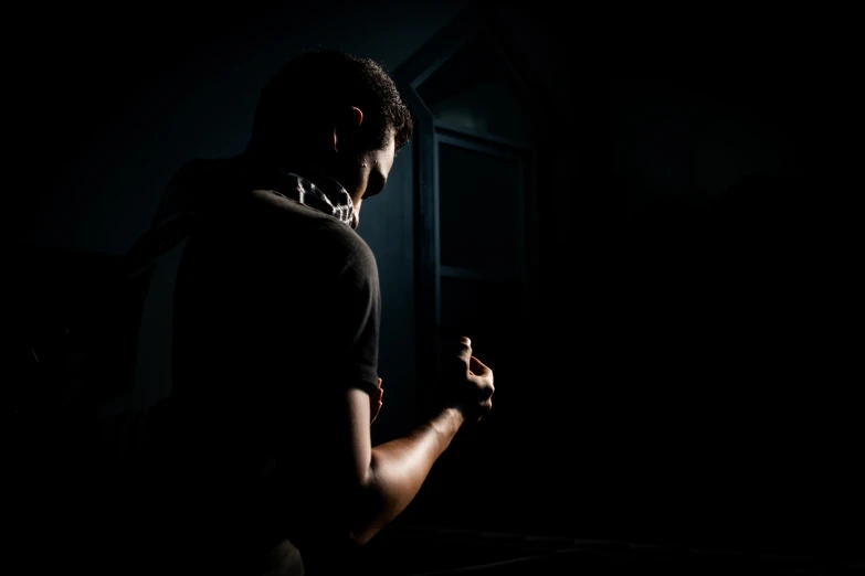 a man looking at his cell phone in the dark, pexels contest winner, hurufiyya, handcuffed, profile posing, back light, profile image