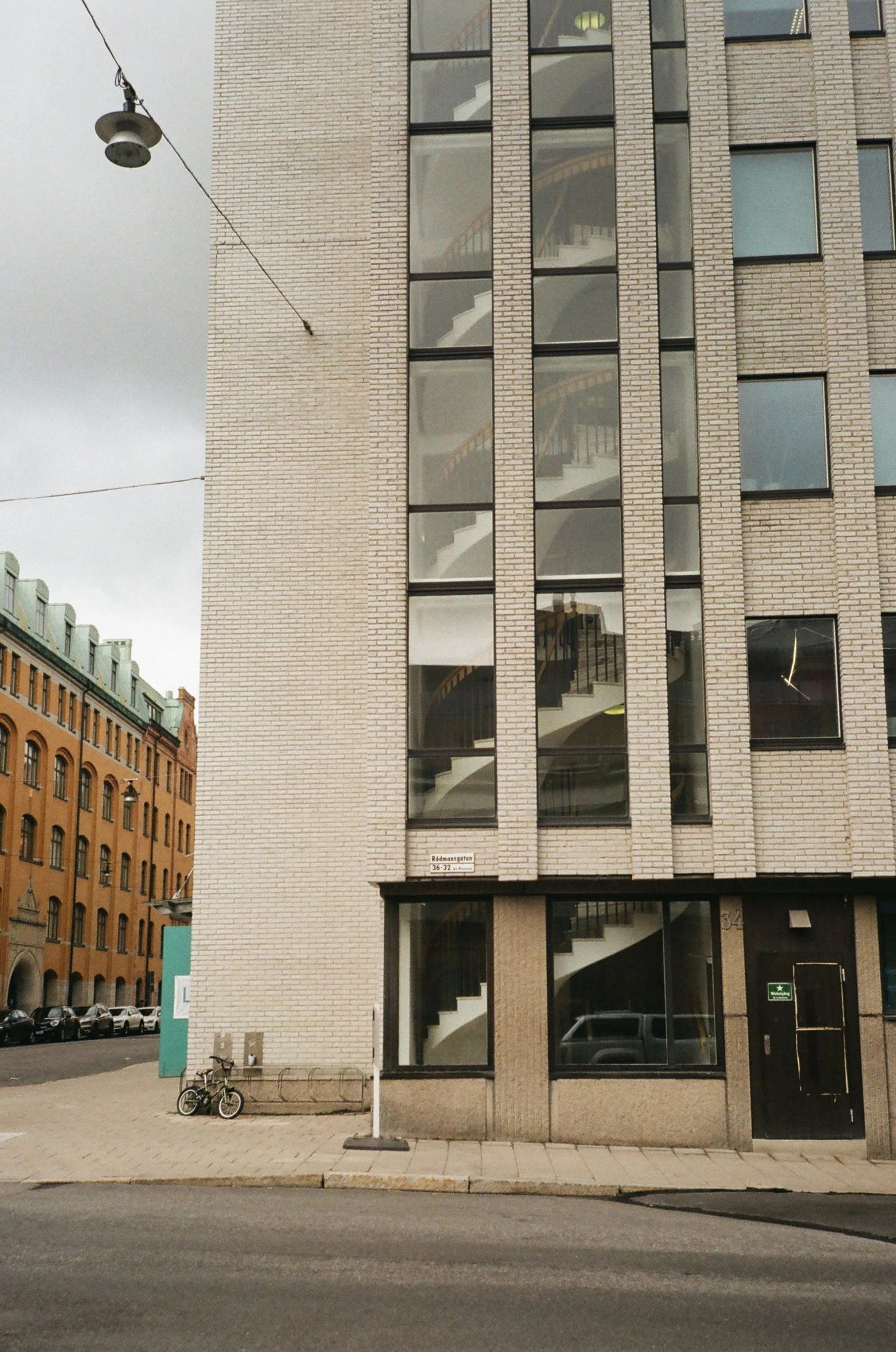 a tall building sitting on the side of a road, by Nina Hamnett, unsplash, modernism, helsinki, storefront, front view 1 9 9 0, stone facade