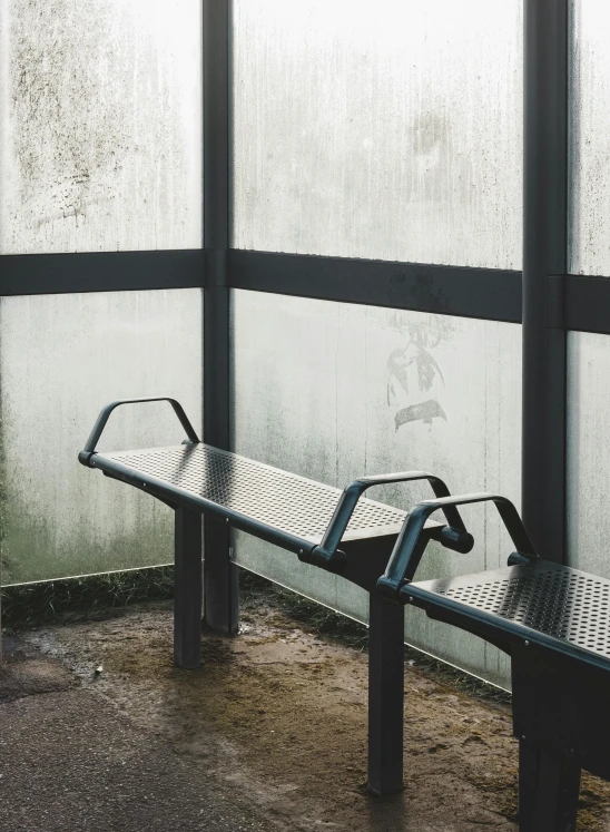 a couple of benches sitting next to each other, inspired by Elsa Bleda, unsplash, graffiti, glass greenhouse, bus stop on a rainy day, peter guthrie, minimal