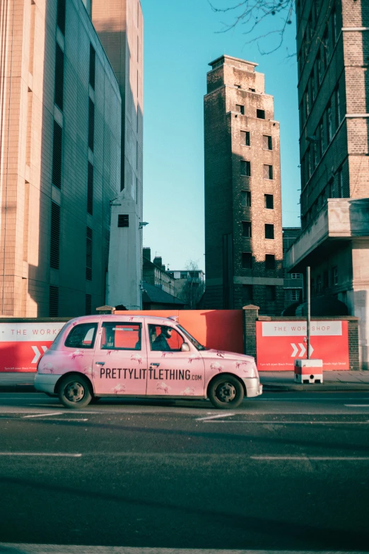 a pink taxi driving down a street next to tall buildings, by Lee Loughridge, pexels contest winner, graffiti, square, photo of poor condition, just a cute little thing, petra collins