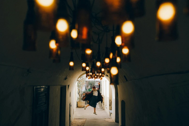 a woman walking down a dark alley way, by Julia Pishtar, pexels contest winner, light and space, lamps and flowers, morrocan lamp, hanging out with orbs, vacation photo