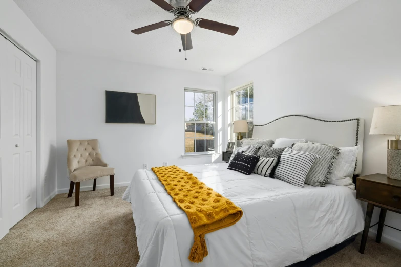 a bed room with a neatly made bed and a ceiling fan, by Carey Morris, pexels contest winner, white and yellow scheme, natural light outside, detailed product image, ready to model