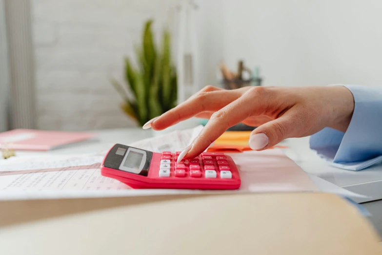 a person using a calculator on a desk, by Julia Pishtar, trending on pexels, private press, pink and red color scheme, 15081959 21121991 01012000 4k, staples, youtube thumbnail