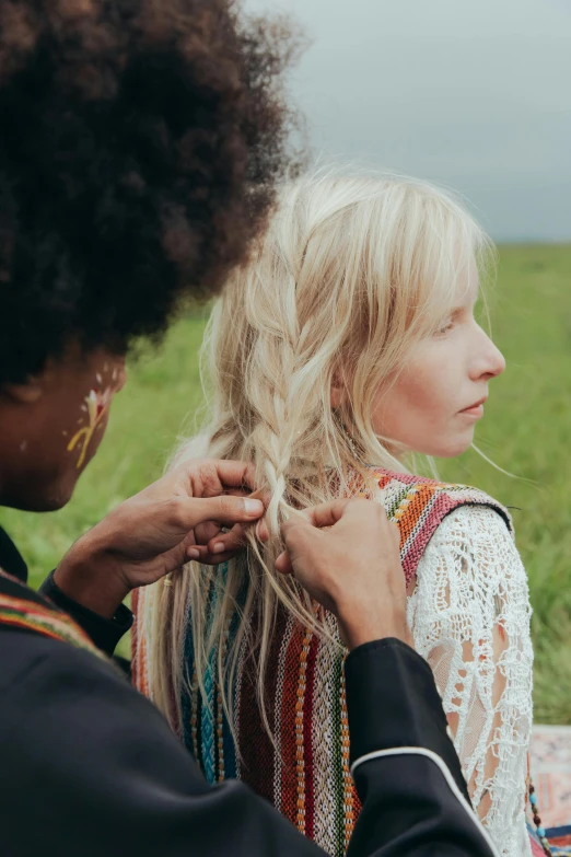 a woman combing another woman's hair in a field, by Anna Boch, trending on pexels, wearing a colorful coogi sweater, high quality film still, blonde crea, mix of ethnicities and genders