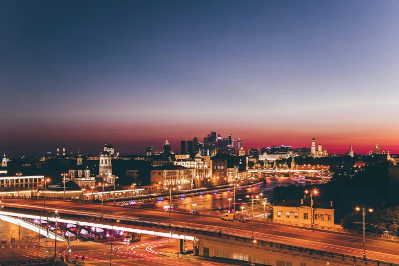 an aerial view of a city at night, an album cover, by Andrei Kolkoutine, pexels contest winner, moscow, twilight skyline, vibrant scene, wide open city ”