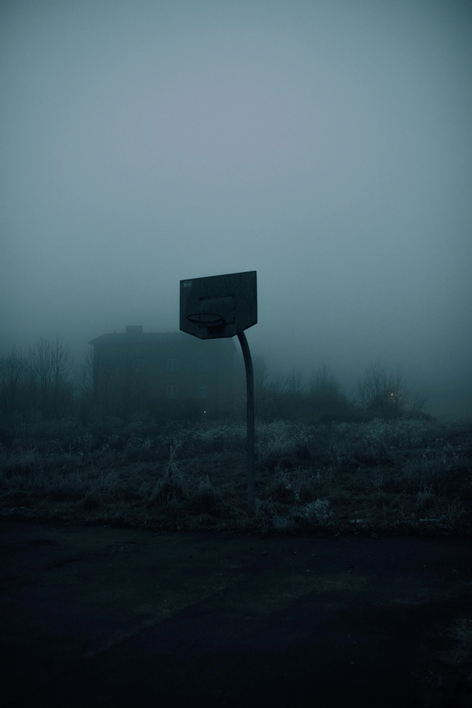 a basketball court in the middle of a foggy field, by Attila Meszlenyi, sign, bleak apocalyptic environment, dark neighborhood, egor letov