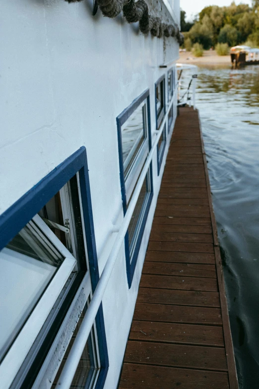 a boat sitting on top of a lake next to a dock, inside large window of ship, bottom body close up, slide show, slightly smiling