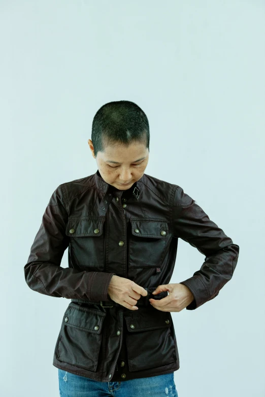 a woman standing with her hands in her pockets, an album cover, inspired by Fei Danxu, brown buzzcut, wearing samcrow leather jacket, like a catalog photograph, photographed for reuters