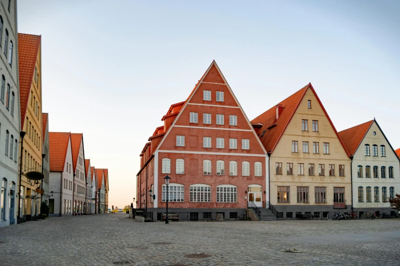 a group of buildings sitting on top of a cobblestone street, an album cover, by Dietmar Damerau, pexels contest winner, renaissance, norrlandsskog, white buildings with red roofs, pritzker architecture prize, exterior view