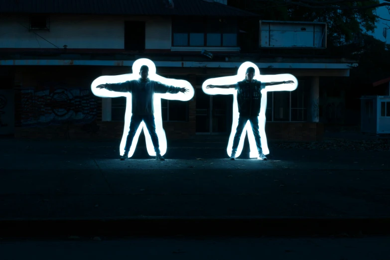 a couple of people that are standing in the street, inspired by Bruce Nauman, unsplash, street art, tron legacy jesus, life size, backlit, bowater charlie and brom gerald