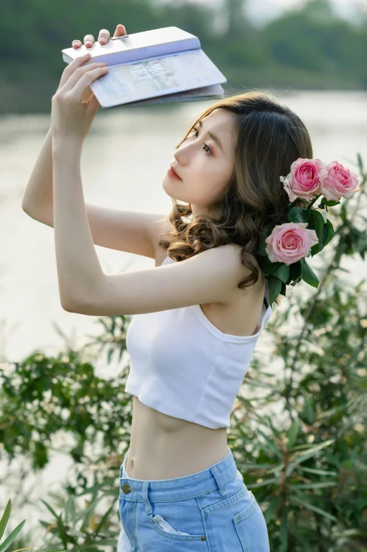 a woman holding a book over her head, by Yang J, unsplash, renaissance, sport bra and shirt, roses, korean women's fashion model, white halter top