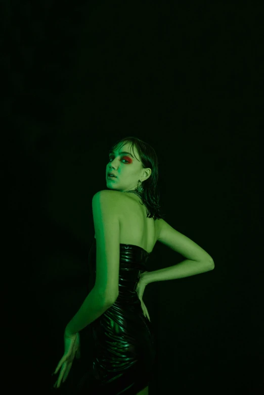 a woman in a black dress in the dark, an album cover, inspired by Elsa Bleda, trending on pexels, green slime, wearing atsuko kudo latex outfit, joey king, looking this way