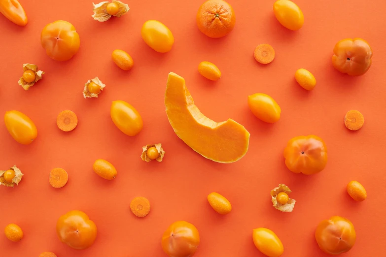 a group of oranges sitting on top of a red surface, made of food