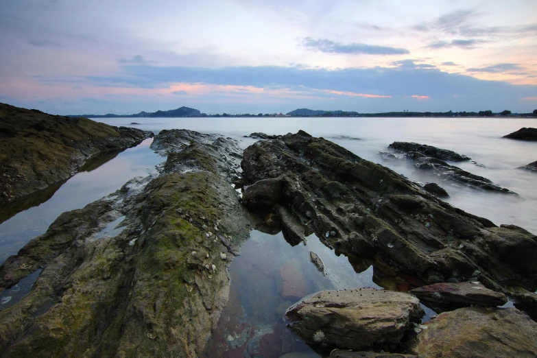 a body of water sitting on top of a rocky beach, by Robert Sivell, south korea, fan favorite, medium format, ultrawide image